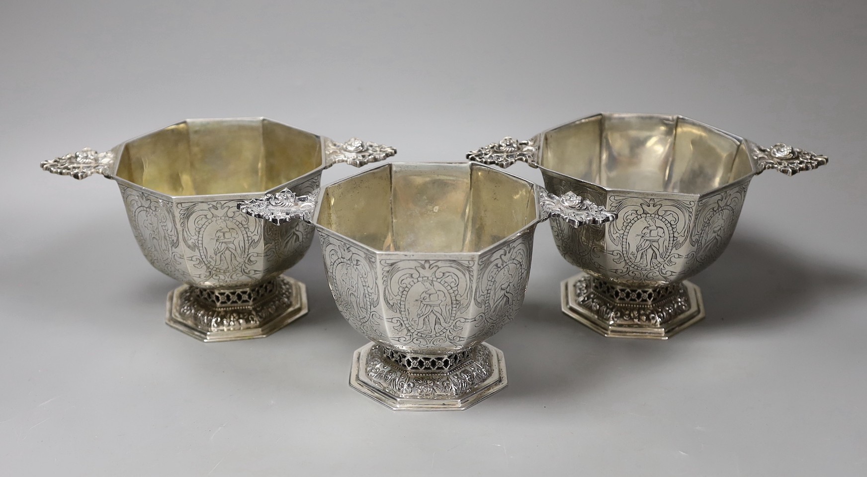 A set of three 19th century Dutch 833 standard white metal octagonal twin mask handled octagonal pedestal bowls, height 10cm, 35.9 oz.
